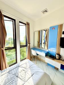 a bedroom with a bed and a desk and windows at Hotel Asia Express near Farmhouse Lembang in Lembang +46 photos