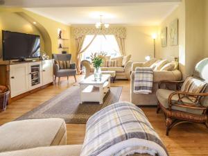 a living room with couches and a tv at Llwyn Derw in Talybont