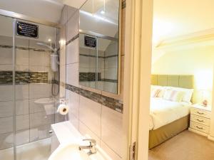 a bathroom with a bed and a shower and a sink at Llwyn Derw in Talybont +59 photos