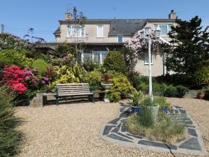 a garden with a bench in front of a house at Llwyn Derw in Talybont