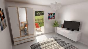a white living room with a tv and a mirror at Les Bastides in Mimizan