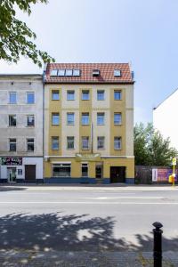 een geel gebouw aan de kant van een straat bij Hotel-Pension ODIN in Berlijn