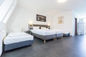 twee bedden in een kamer met witte muren bij Hotel-Pension ODIN in Berlijn +3 foto's
