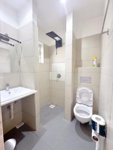 a bathroom with a toilet and a sink at Rio Eco Gardens Hotel in Nairobi