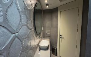 une salle de bain avec des toilettes blanches et un miroir dans l'établissement Atlanticblu hotels & Resort, à Abuja