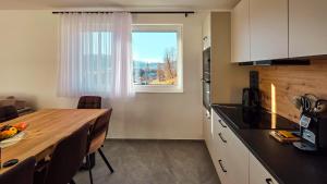 a kitchen with a wooden table and a window at Tauernsky Premium Apartments in Radstadt