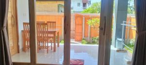 a view of a table and chairs through a sliding glass door at Dharma Yoga Guest House Amed in Amed