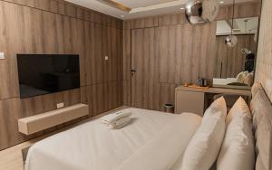 une chambre avec un lit blanc et une télévision dans l'établissement Atlanticblu hotels & Resort, à Abuja