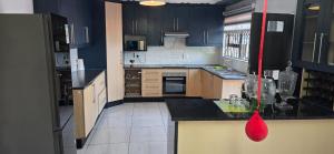 a large kitchen with blue cabinets and a red bag at kiddy in Mogwase