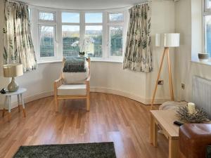 een woonkamer met een stoel, een tafel en ramen bij Island House - Uk51001 in Little Baddow