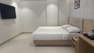 a bedroom with a bed and a flat screen tv at Stae Residency Hitec City in Hyderabad