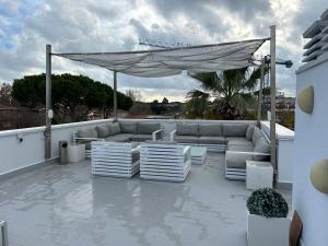 un patio avec un canapé et des chaises sur un toit dans l'établissement Apartamentos ELMA1, à Castelldefels