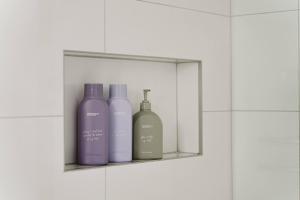 three bottles sitting on a shelf in a bathroom at Allure at Hyams Beach - seconds to white sands in Hyams Beach