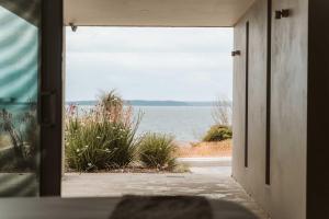 an open door to a view of the water at Allure at Hyams Beach - seconds to white sands in Hyams Beach