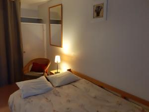 a bedroom with a bed and a chair and a mirror at Studio Gavarnie in Gavarnie