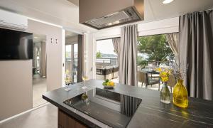 a kitchen with a counter with two wine glasses at Aminess Style Camping Atea Glamping & Holiday Homes in Njivice