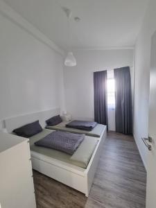 a white bedroom with two beds and a staircase at Ferienwohnung Euchen 2 in Würselen
