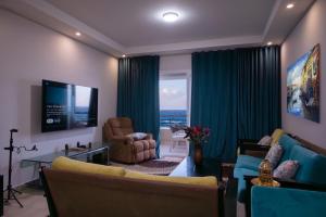 a living room with a couch and a television at Sea Front Zen Chalet Families Only in Marsa Matruh