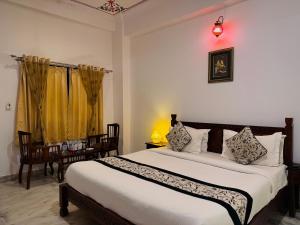een slaapkamer met een groot bed en een geel gordijn bij Atulya Niwas in Udaipur +30 foto's