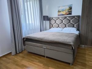 a bedroom with a large bed with a large window at Apartman Iva Brzeće-Kopaonik in Brzeće