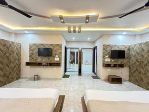 a living room with two beds and a tv at Hotel The Pushpraj in Varanasi