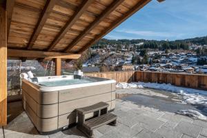 ein Whirlpool auf einer überdachten Terrasse in der Unterkunft Chalet Boheme Les Gets - by EMERALD STAY in Les Gets