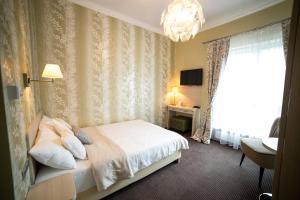 a hotel room with a bed and a chandelier at Hotel Sokołowska Airport Modlin in Nowy Dwór Mazowiecki +27 photos
