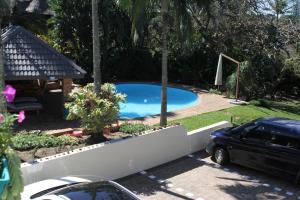 een auto geparkeerd voor een zwembad bij Whalesong Guest House in St Lucia