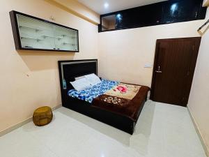 ein kleines Schlafzimmer mit einem Bett und einem Flachbildfernseher in der Unterkunft Shri Bala Ji Guest House in Vrindāvan