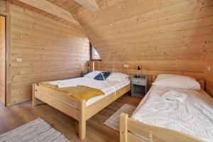 En eller flere senge i et værelse på Domki Falsztyn