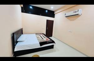 ein kleines Schlafzimmer mit einem Bett und einer Klimaanlage in der Unterkunft Shri Bala Ji Guest House in Vrindāvan