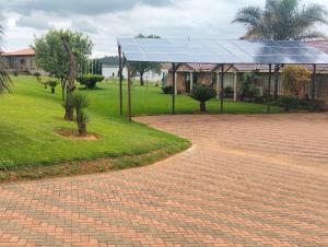 a brick road with a building with a solar roof at Golden Mile Estate Self Check Inn in eMalahleni +10 photos
