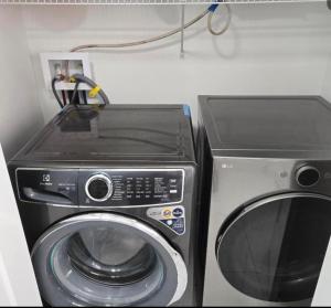 een magnetron en een wasmachine in de kamer bij Platinum Homes Stylish 3BR Home Near Moncton, Dieppe Airport Free Parking in Dieppe