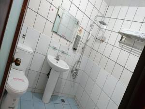 ein weißes Badezimmer mit Toilette und Waschbecken in der Unterkunft Puti Commercial Hotel in Longtan