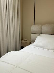 una camera con letto bianco e tenda di شاليه ترف a Ghayl Shabūl