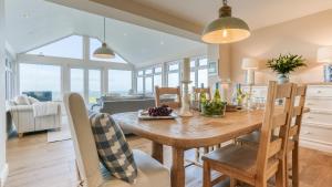 een keuken en eetkamer met een houten tafel en stoelen bij Hafan Nefyn in Nefyn