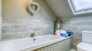 een badkamer met een ligbad en een toilet bij Hafan Nefyn in Nefyn +72 foto's