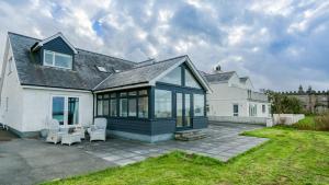 een groot wit huis met veel ramen bij Hafan Nefyn in Nefyn