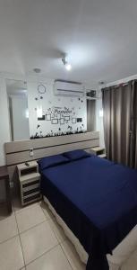 a bedroom with a blue bed and a mirror at Apartamento próximo Aeroporto Cuiabá in Várzea Grande