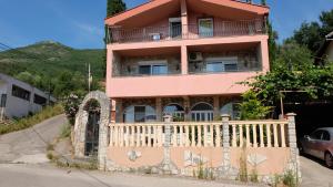 een roze huis met een hek ervoor bij Апартаменты Jasmine in Bar