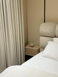 una camera con letto bianco e tenda di شاليه ترف a Ghayl Shabūl