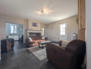 un salon avec un canapé, des fauteuils et une table dans l'établissement Gite de la grand'cour, à Frampas