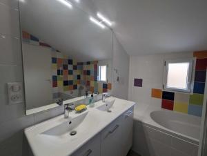 une salle de bain avec deux lavabos, une baignoire et un miroir dans l'établissement Gite de la grand'cour, à Frampas 19 autres photos