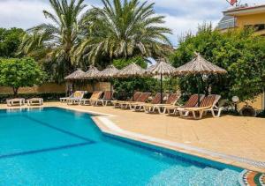a swimming pool with lounge chairs and umbrellas at Paras Sun Hotel & Apartments in Ialysos