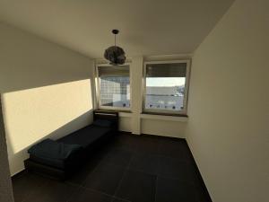 een kleine kamer met een bank en 2 ramen bij Hotelikum in Heilbronn
