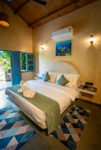 een slaapkamer met een groot bed in een kamer bij Aqua Bella Resort in Mandrem +49 foto's