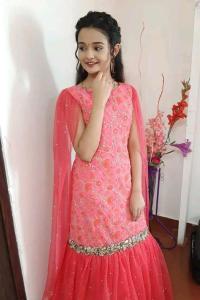 a woman in a red dress standing in a room at রোজ ভ্যালি আবাসিক হোটেল in Dāsnaogaon