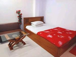 a bedroom with a bed and a chair and a table at রোজ ভ্যালি আবাসিক হোটেল in Dāsnaogaon