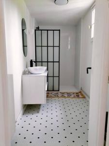 un bagno bianco con lavandino e specchio di Cottage de Vardes a Neufmarché