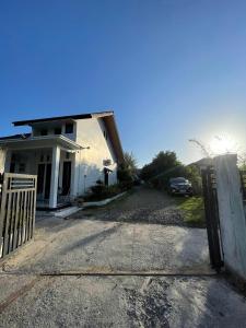 a house with a gate in front of a driveway at Utama Lueng Bata Hotel in Luengbata